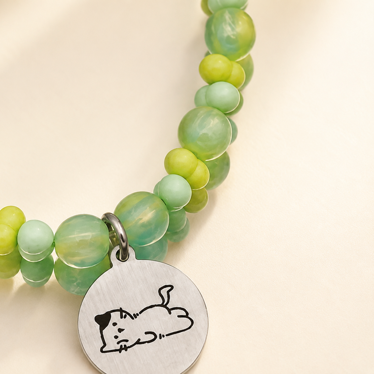 Close detail of green beaded pet necklace and engraved tag